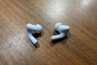 Apple AirPods Pro 2 are pictured on a wooden table